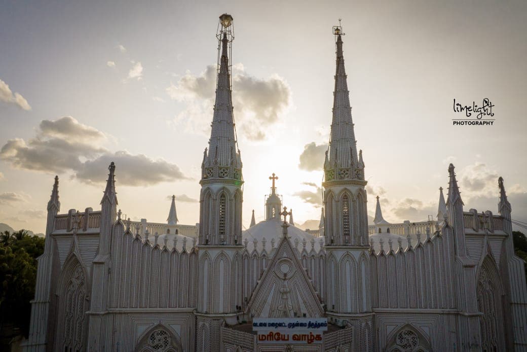 The whole west front of the shrine at dusk, dressed with a feast banner across the lower gable