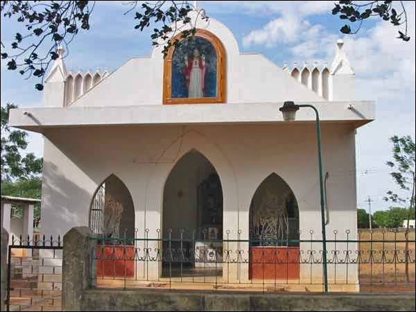 The church of St George at Vadakkankulam — a small white chapel behind an iron railing, a painted image of the saint set above its door